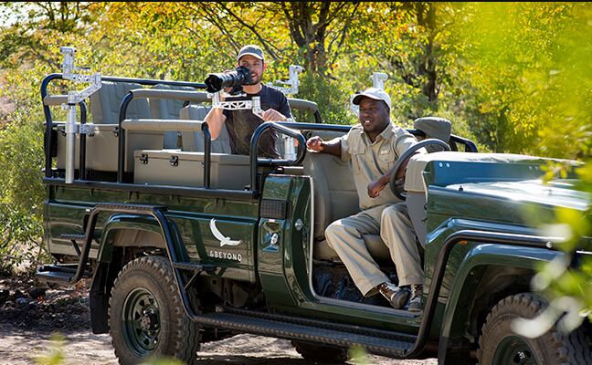 Intondolo Safaris guide beside an open safari vehicle